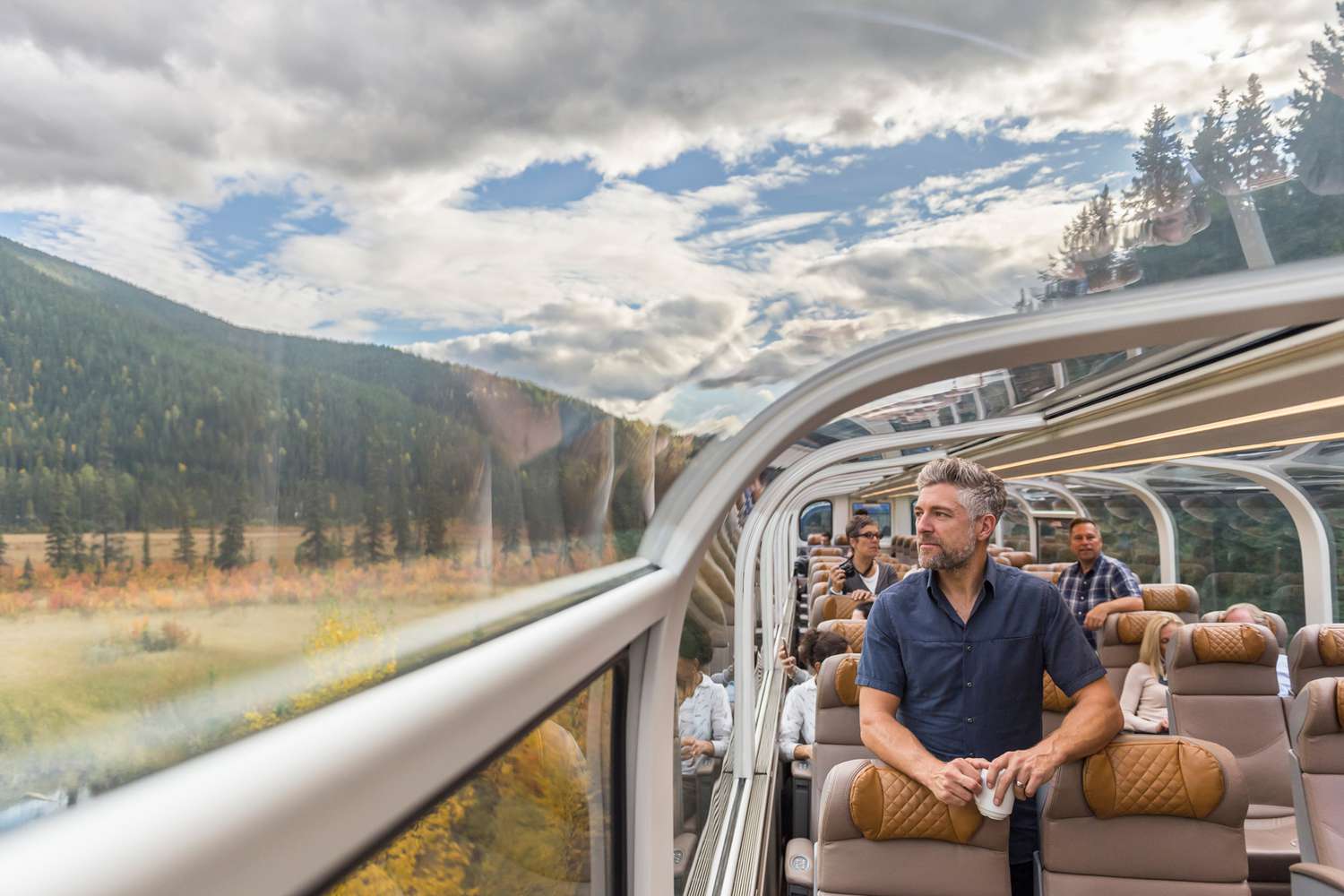 man enjoying scenic journey on train with panoramic windows
